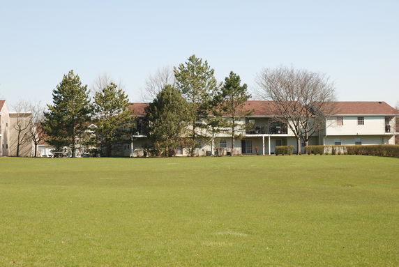 Front view of a multi-story residential building with trees.