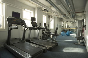 Indoor gym area with exercise equipment including treadmills and exercise balls.