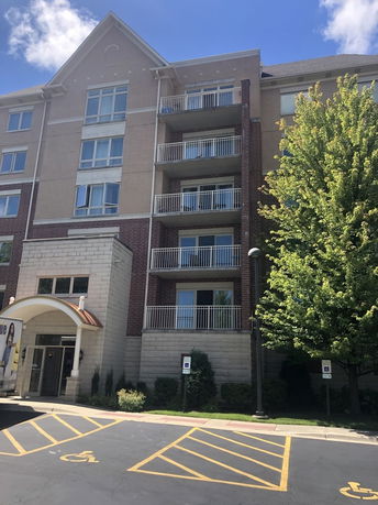 Front view of a multi-story building with balconies and an accessible entryway.