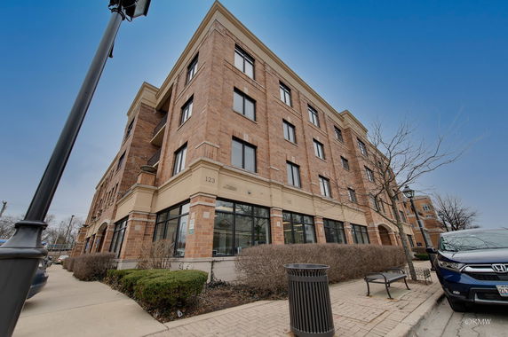 Front view of a multi-story brick building with large windows.