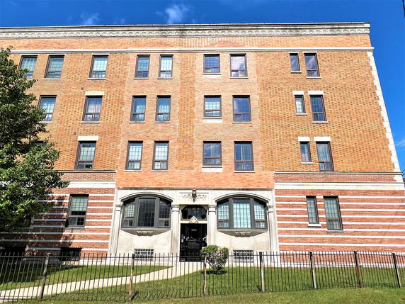 Front view of a multi-story building with brick exterior and multiple windows.