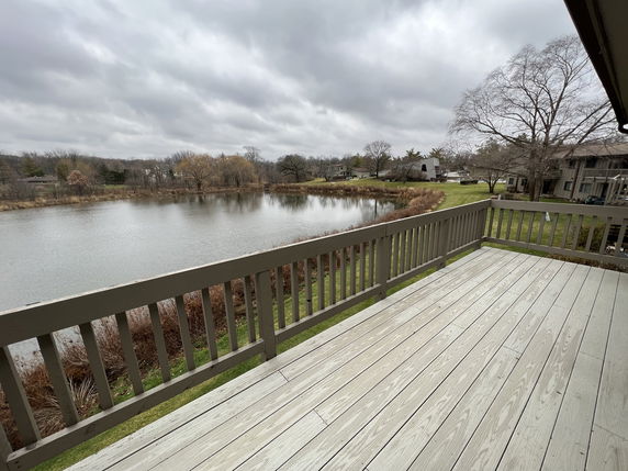 Elevated deck overlooking a serene lake and distant trees.