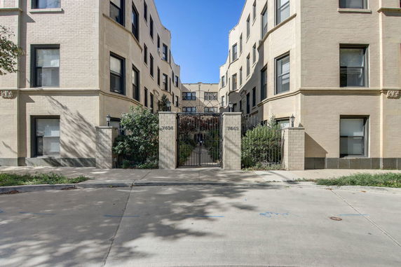 Front view of a multi-story building with a gated entrance.