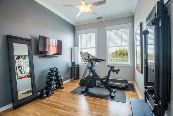 Exercise room with stationary bike and weights.