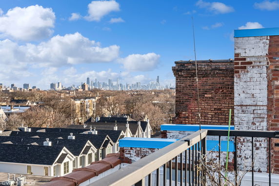 Panoramic view from a rooftop showing a city skyline in the distance.