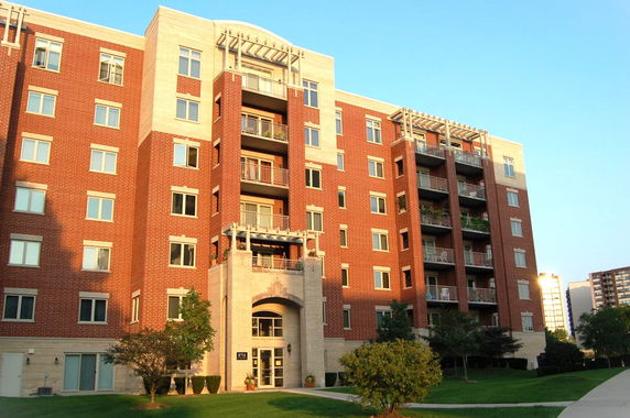 Front view of a multi-story apartment building with red brick facade.