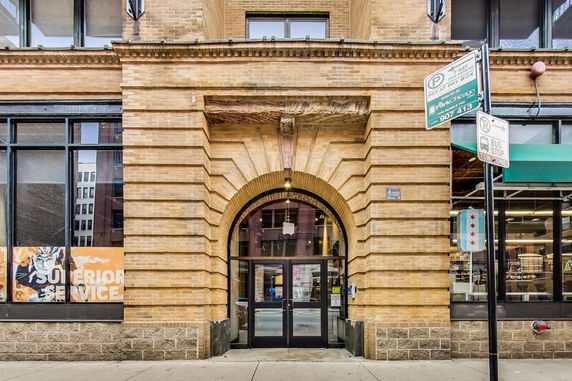 Front view of a brick building entrance with an arched doorway.