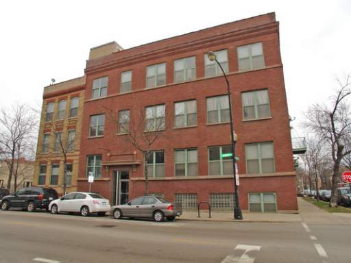 Front view of a multi-story brick building on a city street.
