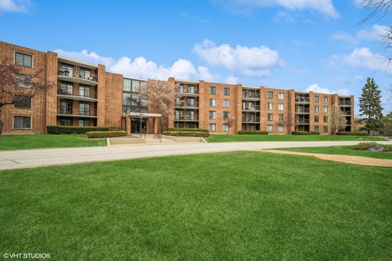 Front view of a multi-story apartment building with brick exterior.