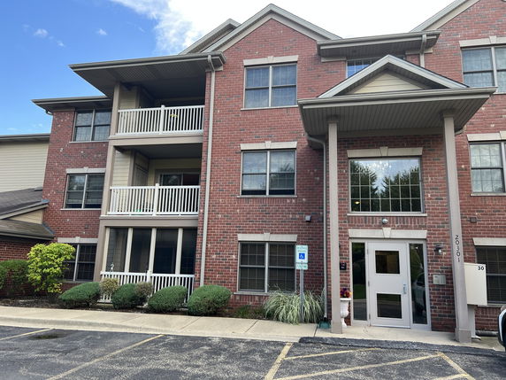 Front view of a multi-story brick building with balconies.