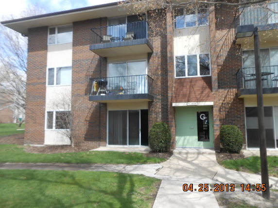 Front view of a three-story apartment building with balconies.