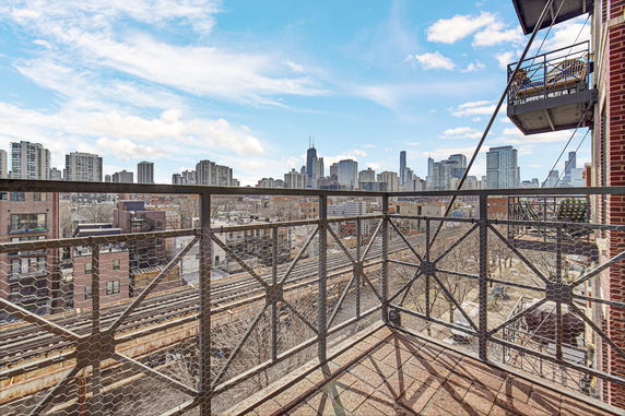 View from a balcony overlooking a city skyline with multiple high-rise buildings.
