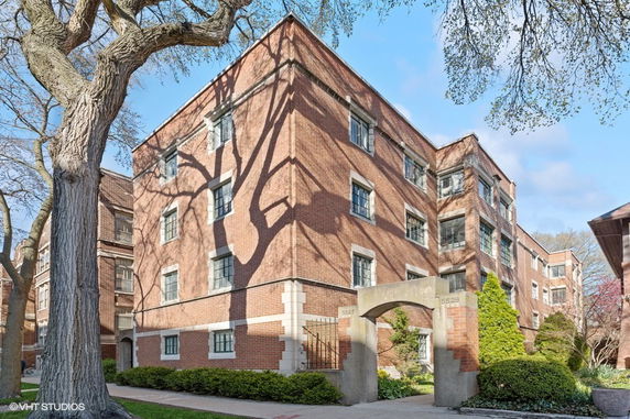 Front view of a multi-story brick building with large windows.