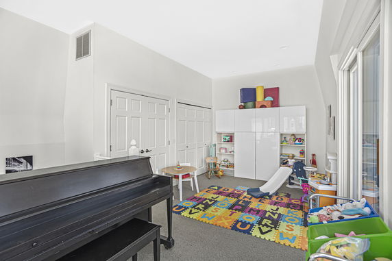 Indoor play area with toys, a small slide, and colorful mat.