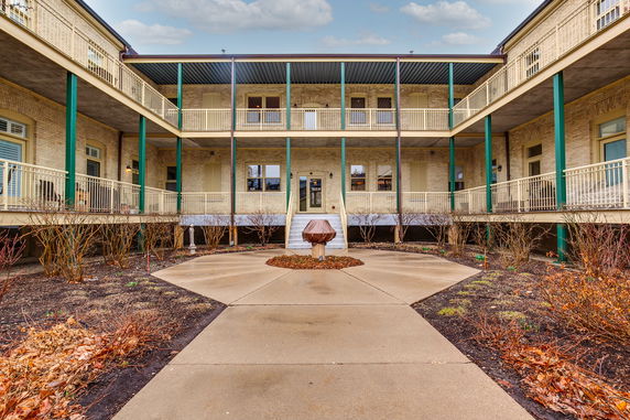 Front view of a two-story building with balconies and columns.