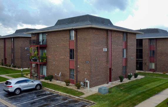 Front view of a brick apartment building with multiple floors.