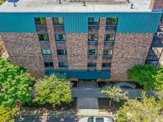 Front view of a multi-story brick building with a green awning at the entrance.