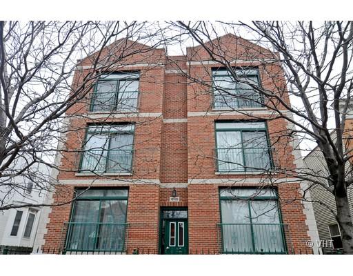 Front view of a multi-story brick building with large windows.