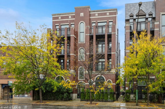 Front view of a multi-story brick building with balconies.