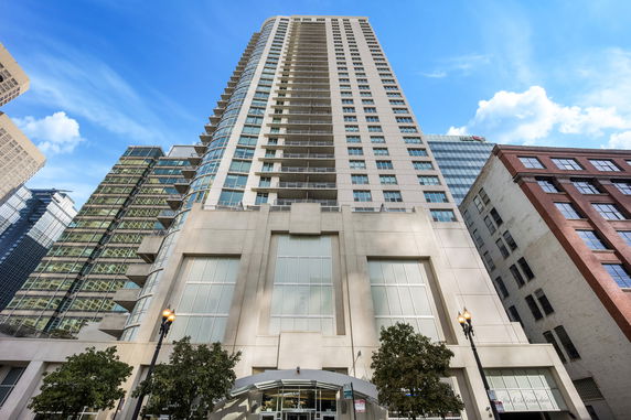 Front view of a tall modern skyscraper with large windows.
