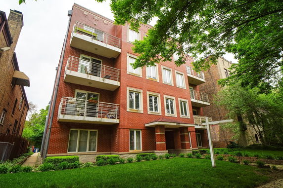 Front view of a multi-story brick building with balconies.