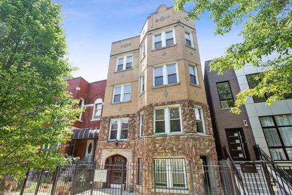 Front view of a multistory residential building with brick and stone facade.