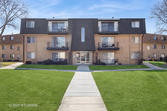 Front view of a three-story apartment building with balconies.