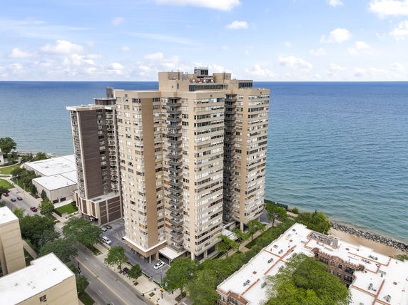 Front view of a high-rise apartment building near a body of water.