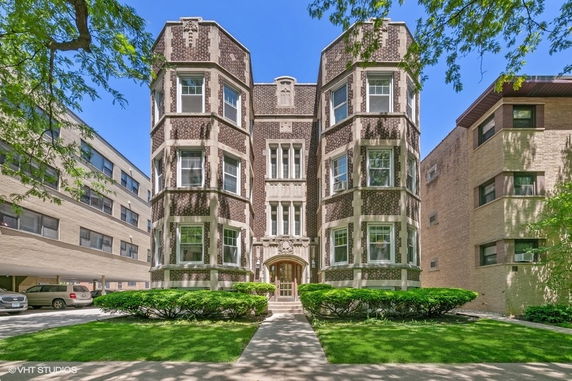 Front view of a multi-story brick building with decorative architectural features.