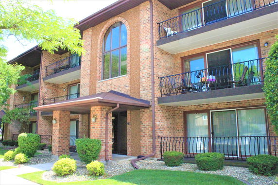 Front view of a multi-story brick building with balconies.