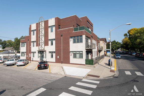 Front view of a modern multi-story building with brick and light-colored facade.