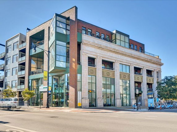 Front view of a multi-story building with modern and classic architectural elements.