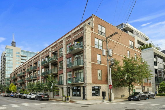 Front view of a multi-story brick apartment building with balconies.