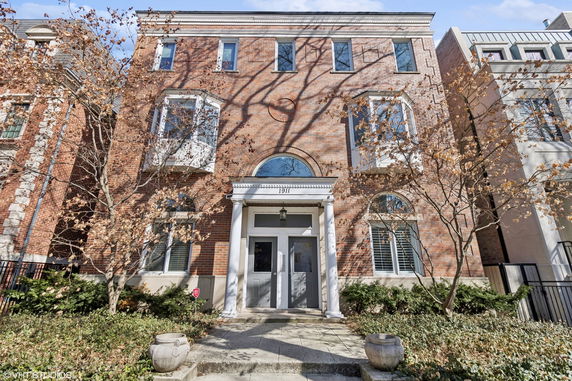 Front view of a three-story brick building with symmetrical windows and a central entrance.