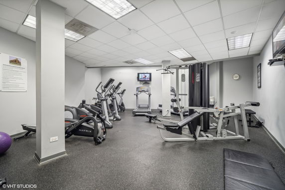 Indoor gym area with exercise equipment and machines.