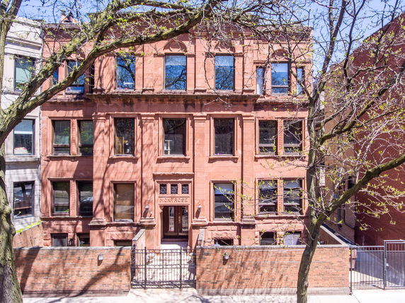 Front view of a multi-story brick building with multiple windows.
