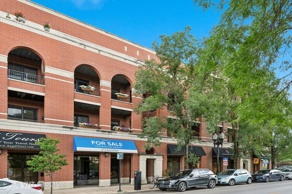 Front view of a multi-story brick building with commercial spaces.