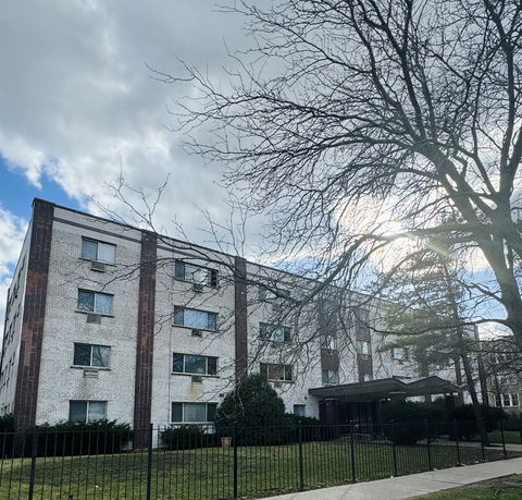Front view of a four-story brick apartment building.