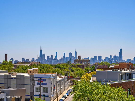 Wide angle view of a city's skyline with tall buildings and clear blue sky.