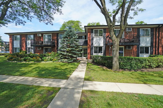 Front view of a two-story apartment building with balconies.