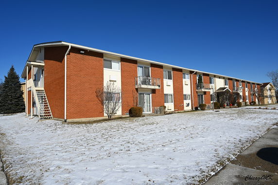 Front view of a two-story apartment building with brick and siding exterior.