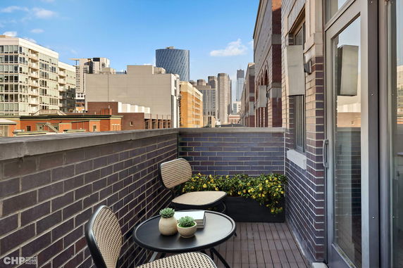 Balcony view overlooking urban buildings with seating area.