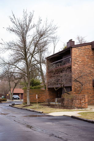 View of a multi-story brick building with balconies.