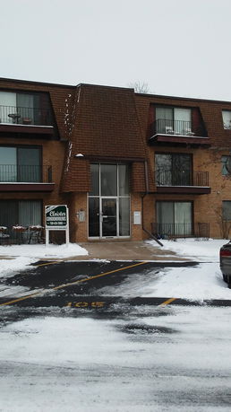 Front view of a three-story condominium building with balconies.