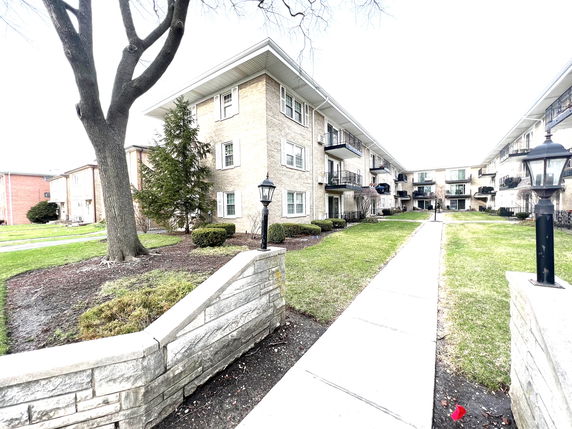 Front view of a multi-story apartment building with balconies.