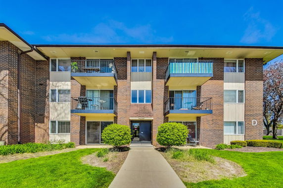 Front view of a multi-story apartment building with balconies.