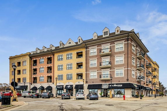 Front view of a multi-story commercial and residential building with shops at ground level.