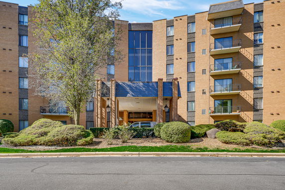 Front view of a multi-story apartment building with balconies.