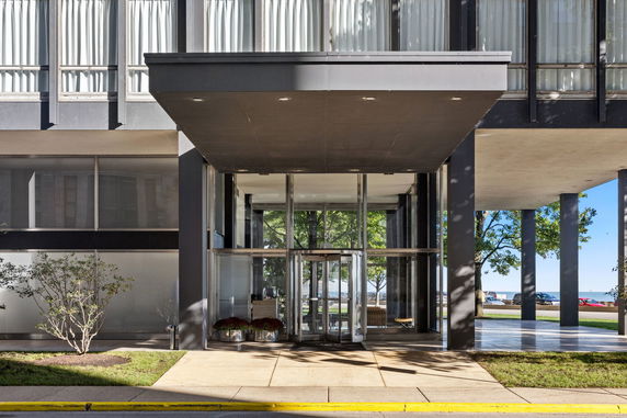 Front view of a modern building entrance with large glass doors and tall windows.