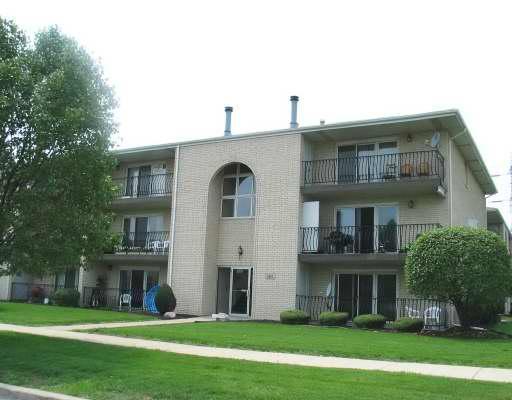 Front view of a three-story apartment building with balconies.